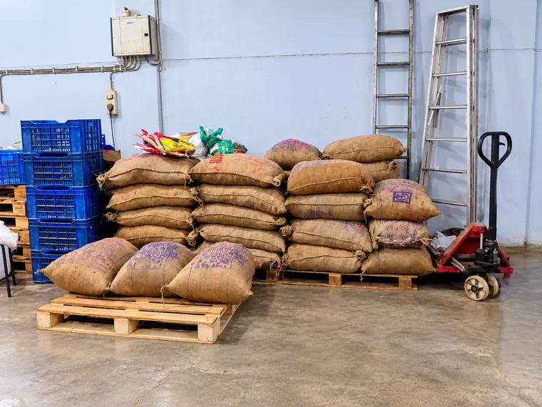 Seed sacks beside a pallet truck in the LivOil store room